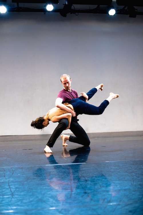 Austin Seldon kneels while holding his partner Sarah Konner horizontal in the air